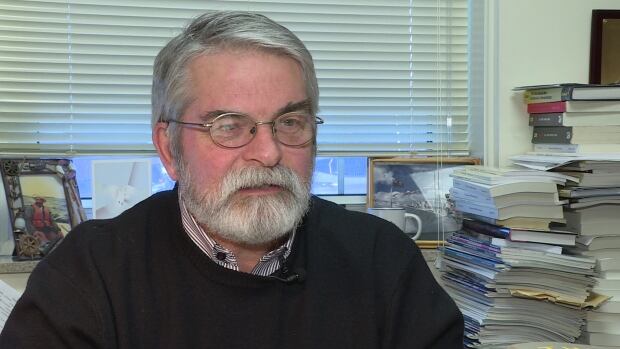 Marc Milner of UNB's Gregg Centre for the Study of War and Society spent time onboard HMCS Fredericton five years ago. A man with grey hair, a beard and glasses sitting in an office
