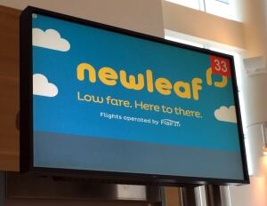 NewLeaf Travel Company sign at Winnipeg airport
