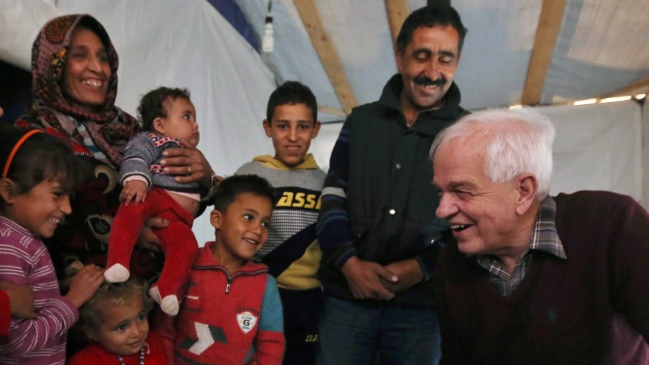 Canadian Minister of Immigration John McCallum, right, speaks with a Syrian family inside their tent, during his visit to a refugee camp in the southern town of Ghaziyeh, near the port city of Sidon, Lebanon, Friday, Dec. 18, 2015.