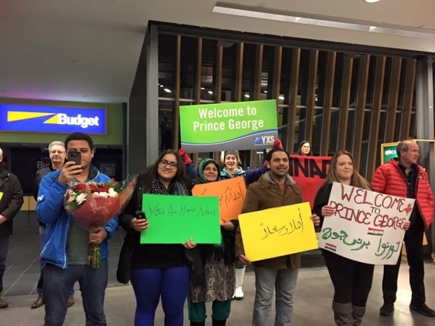 Hira Rashid of Prince George's Muslim community holds "you are home now" sign