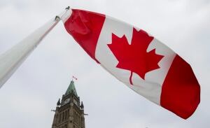 Canadian flag flying near Parliament buildings