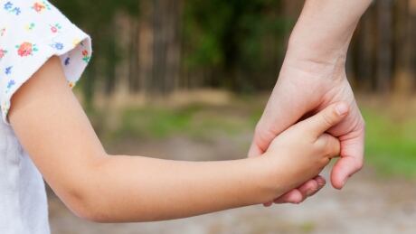 mother and child holding hands stock photo
