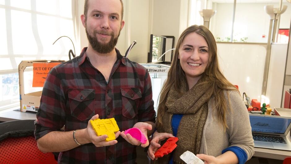 Graduate students Jennifer Grayburn and Benjamin Gorham hold examples of artifacts and archaeological dig sites they’ve recreated using an Ultimaker 3D printer