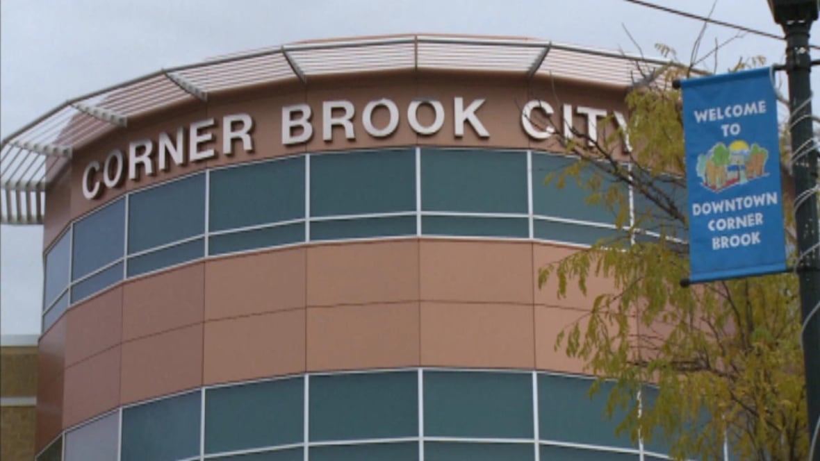 The top part of a building, with windows in the front, and the words "Corner Brook City" visible as part of a sign on the building.