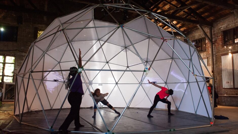 Dancers from the T Lang Dance Company perform in a geodesic dome. The LuminAI dances with them, learning and collaborating instead of just mimicking.