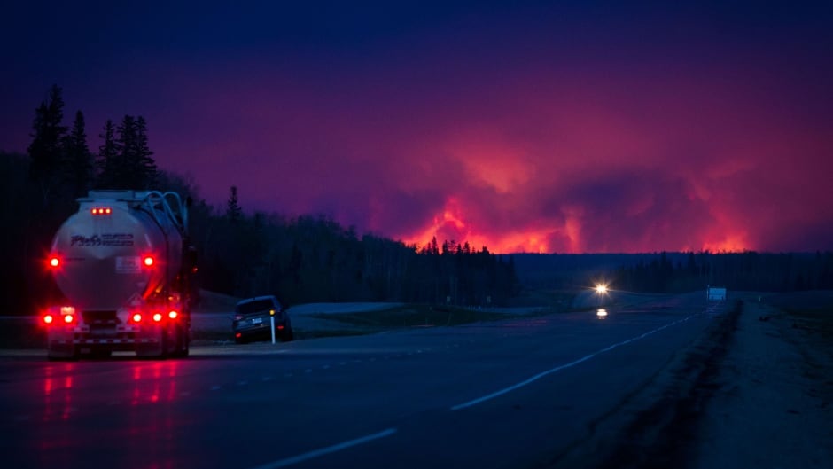 A truck drives on a highway as wildfire burns south of Fort McMurray, Alberta, Canada, on Wednesday, May 4, 2016.