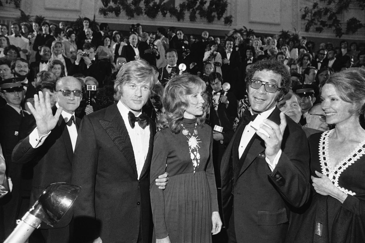 Cuatro actores y actrices en una foto en blanco y negro posan para una foto en una alfombra roja.