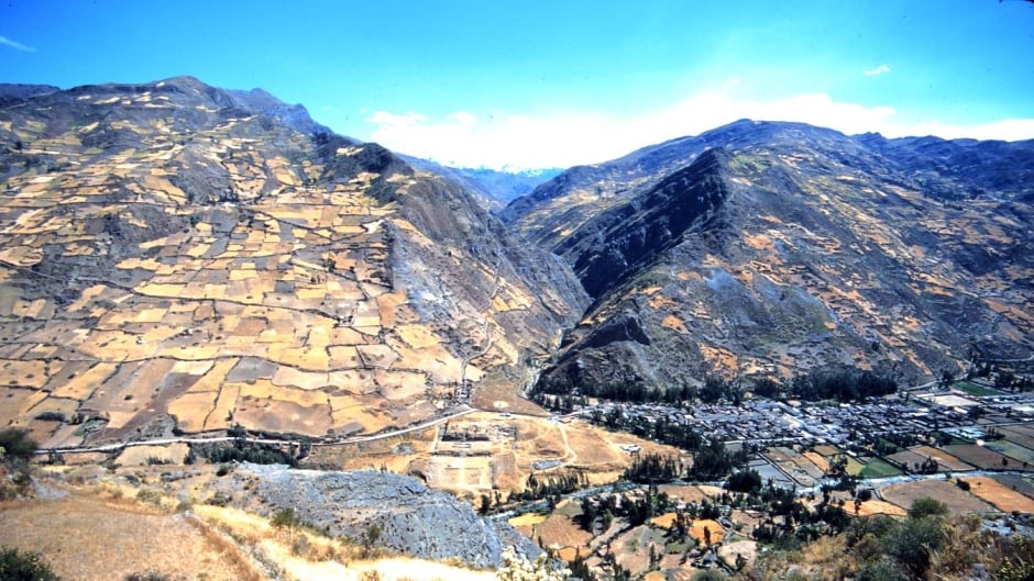 Chavín de Huántar, Peru, with site in middle, modern town on the right and the Cordillera Blanca mountains visible in the distant centre.