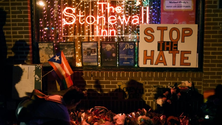 A man lights a candle at a memorial outside The Stonewall Inn following the shooting massacre at Orlando's Pulse nightclub on June 12, 2016.