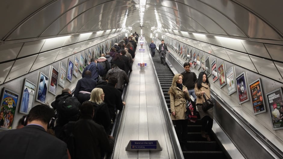 Commuters make their way on the escalator at Angel Underground station.