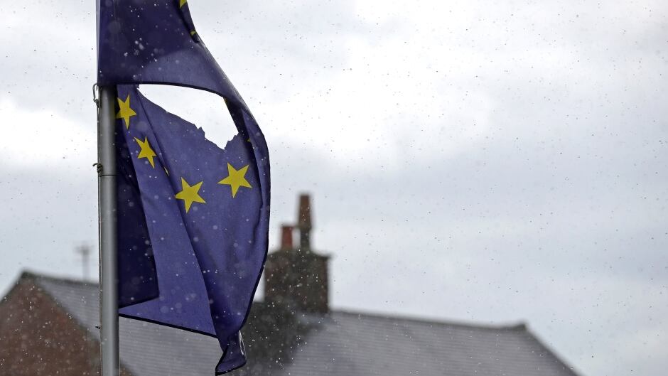 A European Union flag, with a hole cut in the middle, flies at half mast outside a home in Knutsford, Cheshire on June 24, 2016. The results from the historic EU referendum have now been declared and the United Kingdom has voted to leave the European Union.