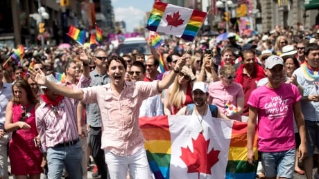 Prime Minister Justin Trudeau waves a flag as he takes part in the annual Pride Parade in Toronto on Sunday, July 3, 2016. Toronto Pride Parade 20160703