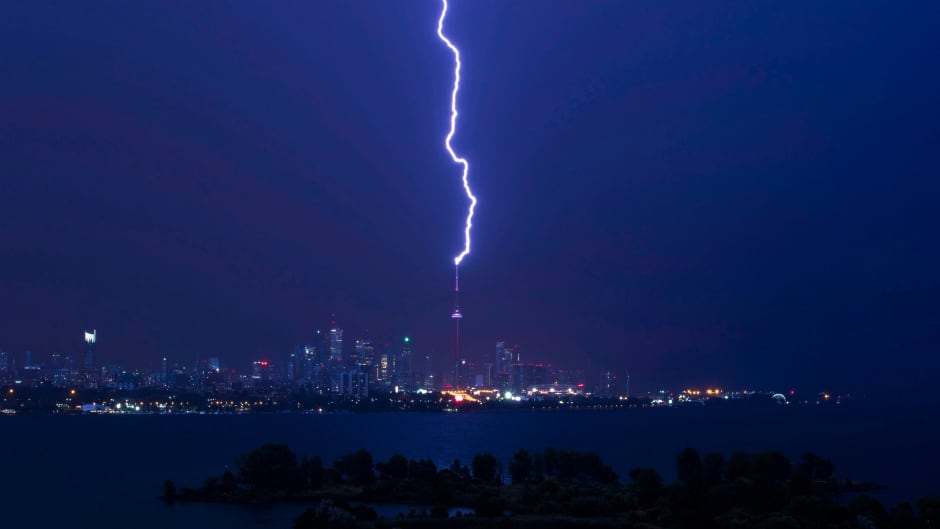 A lightning bolt strikes the CN Tower in Toronto as heavy winds and rain batter the city and cause delays for people trying to get around on July 25, 2016.