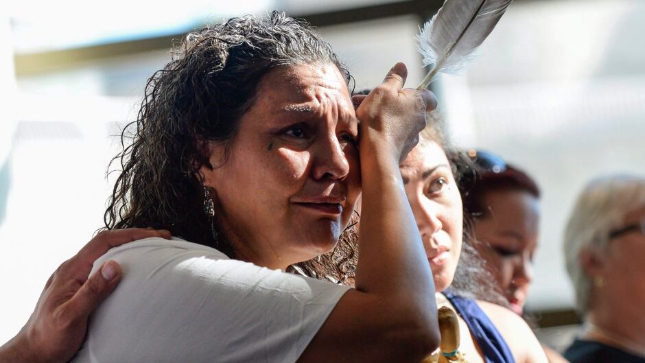Ceejai Julian, who lost two sisters, wipes her eye during the announcement of the inquiry into missing and murdered Indigenous women.