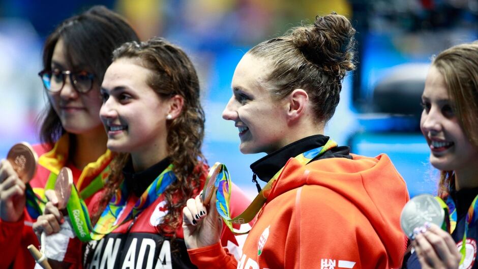 (R-L) Silver medalist Kathleen Baker of the United States, gold medal medallist Katinka Hosszu of Hungary and bronze medalists Kylie Masse of Canada and Yuanhui Fu of China pose on the podium during the medal ceremony for the Women's 100m Backstroke Final on Day 3 of the Rio 2016 Olympic Games.