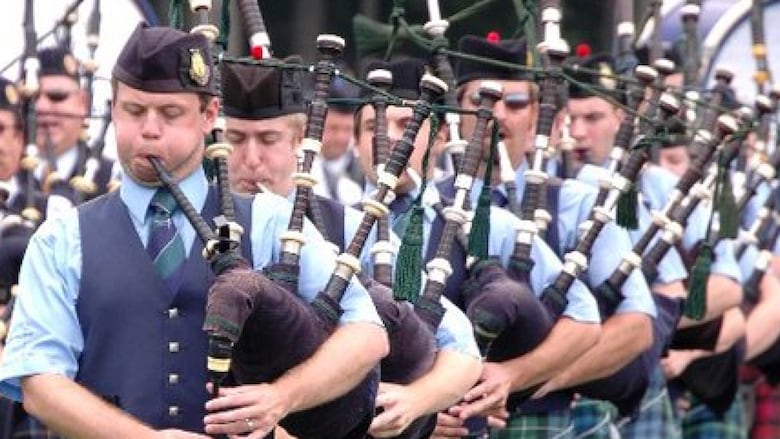 A line of men playing bagpipes