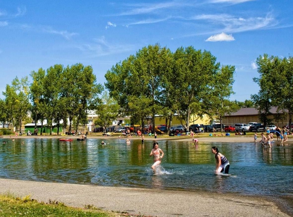 Kids swim in a lake.