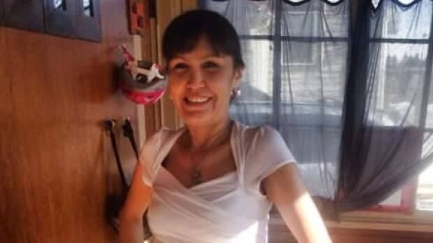 Gloria Gladue went missing almost one year ago, and her daughter says the family has more questions than answers. An Indigenous woman, wearing a white t-shirt and black sweatpants, is posing for a photo inside a home. With her dark hair tied back, she is smiling while placing her hands on her hips.
