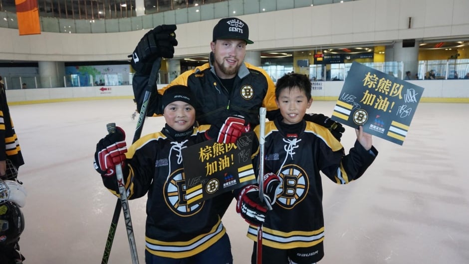 Boston Bruins forward Matt Beleskey poses with young hockey players in China. Beleskey was part of a tour to grow the game of hockey in the far east.