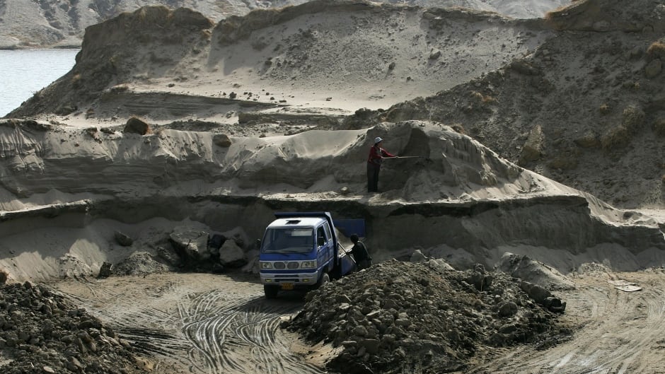 Chinese laborers extract sand from dirt along the river bank March 19, 2006 on the outskirts of Beijing, China. The sand that they mine will be used to build new houses.