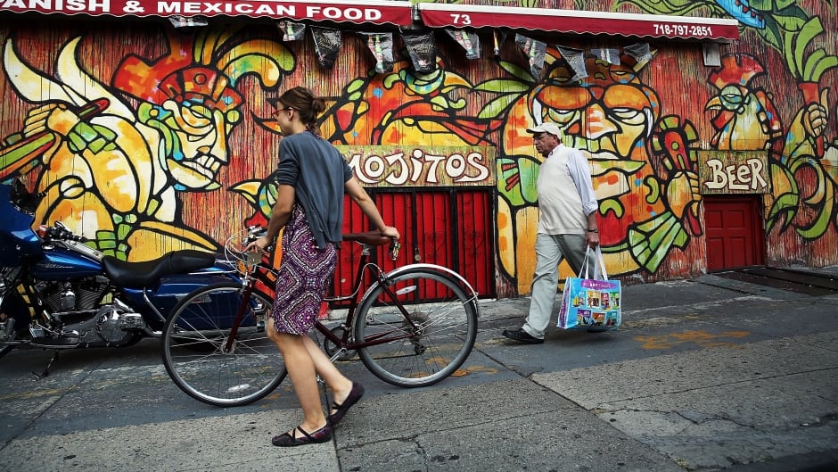 People walk down a popular shopping street in the rapidly developing neighbourhood of Dumbo in the Brooklyn borough of New York City.