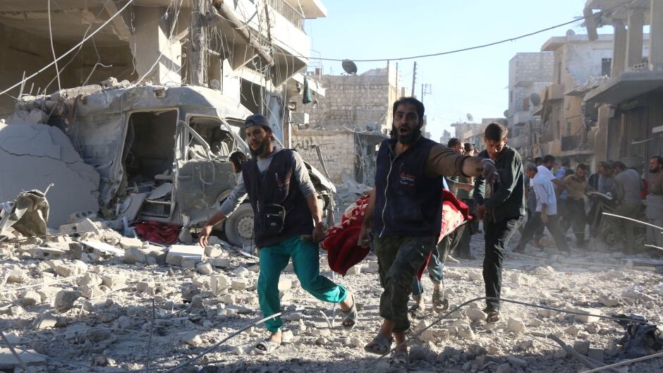 Syrian volunteers carry an injured person on a stretcher following Syrian government forces airstrikes on the rebel held neighbourhood of Heluk in Aleppo, on September 30, 2016. Syrian regime forces advanced in the battleground city of Aleppo, backed by a Russian air campaign that a monitor said has killed more than 3,800 civilians in the past year.
