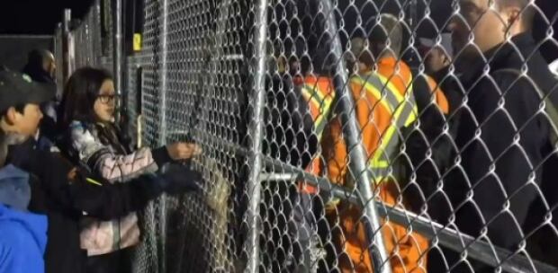 Kid protesters and Muskrat Falls workers separated by a gate