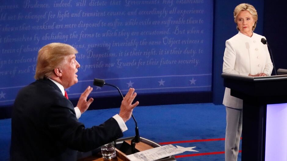 Republican nominee Donald Trump gestures as Democratic nominee Hillary Clinton looks on during the final presidential debate at the Thomas & Mack Center on the campus of the University of Las Vegas in Las Vegas, Nevada on October 19, 2016.