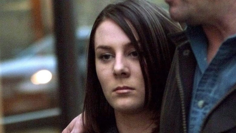 A young woman with straight brown hair looks sullen.