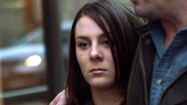 A young woman with straight brown hair looks sullen. 