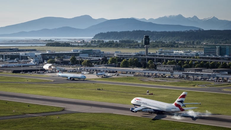 A plane lands on a runway at YVR.