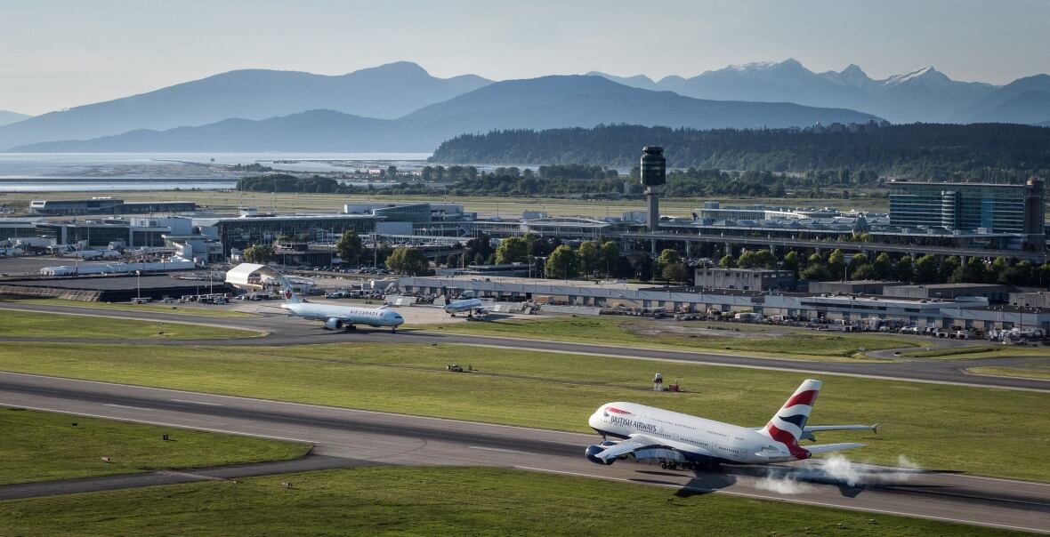 A plane lands on a runway at YVR.