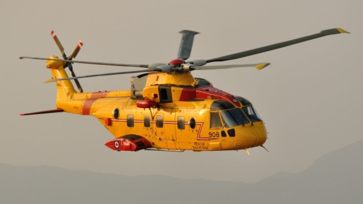 A yellow helicopter flying.