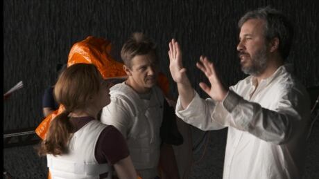 Arrival director Denis Villeneuve talks to Amy Adams and Jeremy Renner on set. Denis Villeneuve