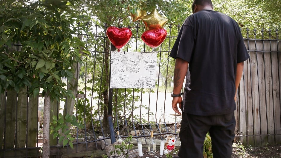A Chicago man looks over a memorial for his friend who was shot and killed this summer. This has been the city's deadliest year in two decades.