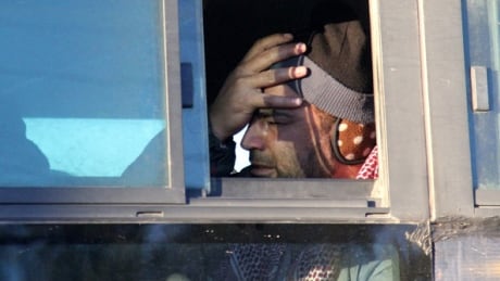 TOPSHOT - A Syrian, who was evacuated from rebel-held neighbourhoods in the embattled city of Aleppo, reacts as he arrives in the opposition-controlled Khan al-Aassal region, west of the city, on December 15, 2016, the first stop on their trip, where humanitarian groups will transport the civilians to temporary camps on the outskirts of Idlib and the wounded to field hospitals.
A convoy carrying the first evacuees from rebel-held parts of Syria's Aleppo arrived in opposition territory west of the city on Thursday, a doctor there and a monitor said. / AFP / Omar haj kadour (Photo credit should read OMAR HAJ KADOUR/AFP/Getty Images) AFP_J61EM