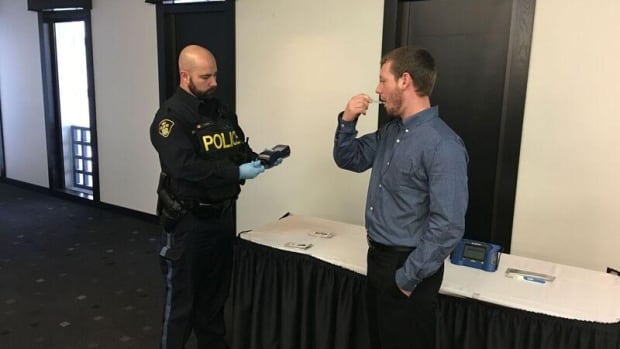 An Ontario Provincial Police officer demonstrates the use of a roadside drug-screening device. The Toronto Police, along with the OPP,  are taking part in a pilot project testing two such devices.