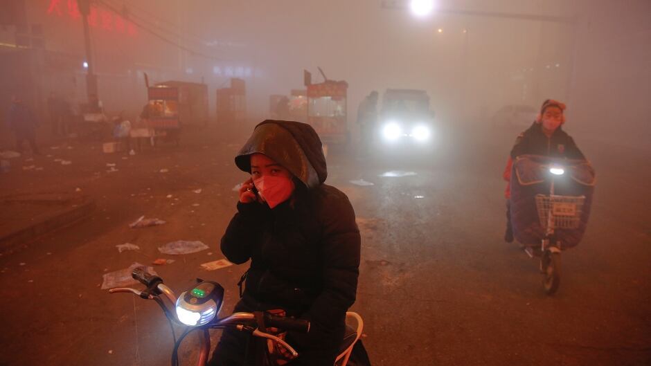 People make their way through heavy smog on an extremely polluted day with red alert issued, in Shengfang, Hebei province, China December 19, 2016.