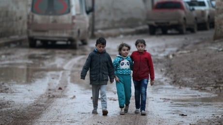 Children walk near a parked ambulance in al-Rai town, northern Aleppo province, Syria December 27, 2016. REUTERS/Khalil Ashawi - RTX2WMY2 MIDEAST-CRISIS/SYRIA