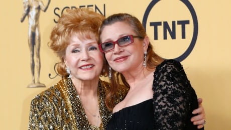 Actress Debbie Reynolds poses with her daughter actress Carrie Fisher backstage after accepting her Lifetime Achievement award at the 21st annual Screen Actors Guild Awards in Los Angeles, California January 25, 2015. AWARDS-SAG/