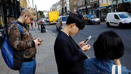 Pedestrians look at their mobile phones near Brick Lane in London, Britain October 5, 2016. NOKIA CORP-SMARTPHONE/
