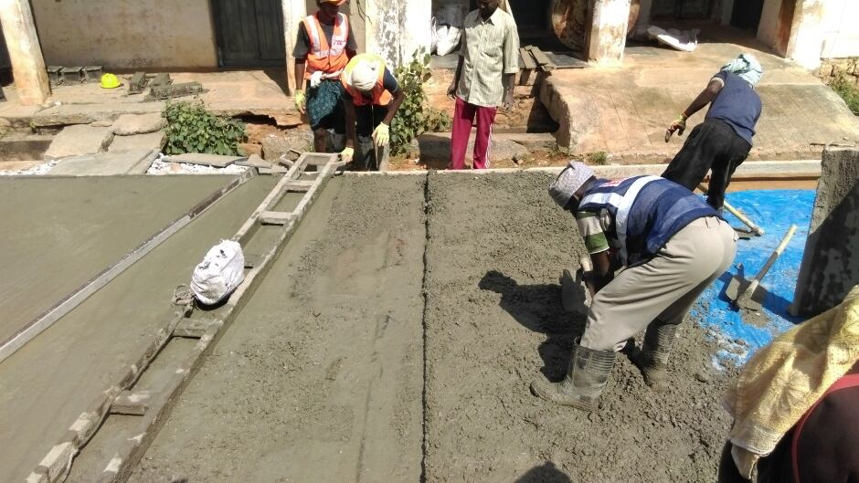 A crew works to build a concrete road in the Indian village of Thondebhavi, in Karnataka, India. But it's not just any concrete - within this material lies the capacity to self-repair cracks.