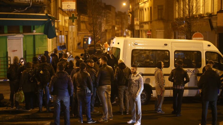 People gather at the scene after raids in which several people, including Paris attacks suspect Salah Abdeslam, were arrested on March 18, 2016 in Sint-Jans-Molenbeek, Belgium. Belgian police arrested three people in raids including key Paris attacks suspect Salah Abdeslam according to Belgian Prime Minister Charles Michel.