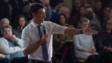 Prime Minister Justin Trudeau gestures to a member of the audience during the question-and-answer session during a town hall meeting in Kingston, Ont., on Jan. 12, 2017. Trudeau Tour 20170112