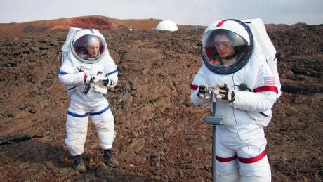 In this May 23, 2014 photo provided by the University of Hawaii, Lucie Poulet, right, uses a geotechnical tool while Annie Caraccio records the data during a previous study outside the domed structure that will house six researchers for eight months in an environment meant to simulate an expedition to Mars, on Mauna Loa on the Big Island of Hawaii. The group will enter the dome Thursday, Jan. 19, 2017, and spend eight months together in the 1,200-square-foot research facility in a study called Hawaii Space Exploration Analog and Simulation (HI-SEAS). They will have no physical contact with any humans outside their group, experience a 20-minute delay in communications and are required to wear space suits whenever they leave the compound. Hawaii Mars Simulation