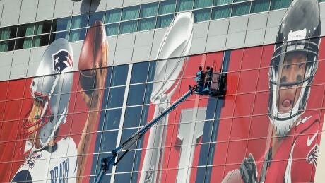 Workers attach a sign to the front of NRG Stadium as preparations continue for the NFL Super Bowl 51 football game Sunday, Jan. 29, 2017, in Houston. Patriots Falcons Super Bowl Football