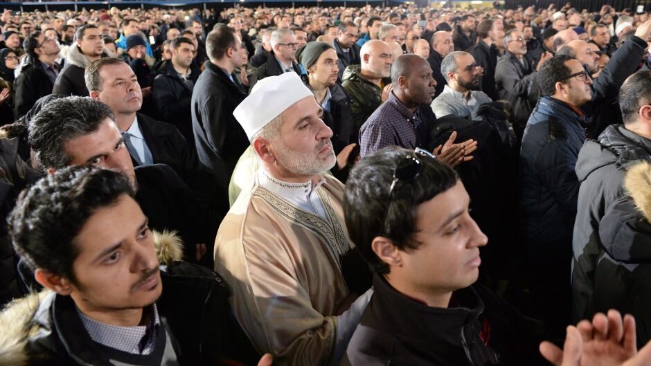 Mourners applaud during the funeral service for three of the six victims of the Quebec City mosque shooting at the Maurice Richard Arena in Montreal.