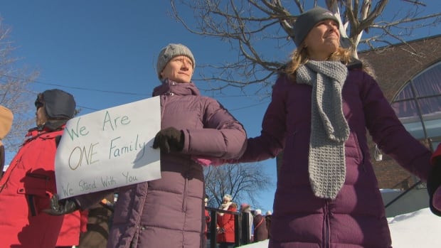 Andrea Prazmowski, left, joins the human chain at the Ottawa Mosque Feb. 3