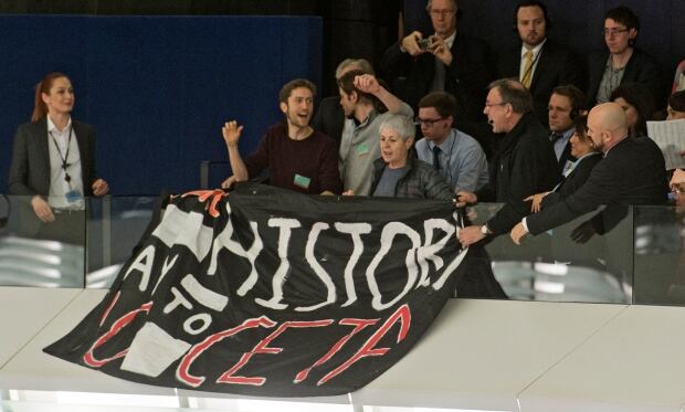 Spectators unfold a banner against CETA