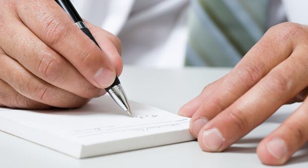 Shutterstock prescription pad doctor signing